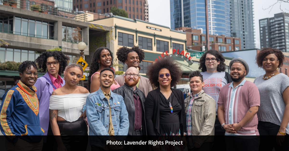 12 people standing in front of Pike Place Market smiling for a group photo.